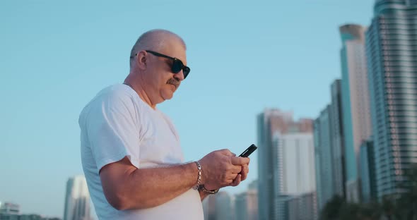 Mature Senior Man Walking Texting on Cell Phone