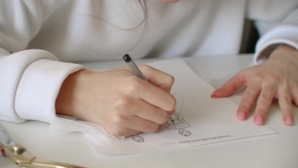 Designer of Clothes Makes an Outline of Clothes with a Felttip Pen