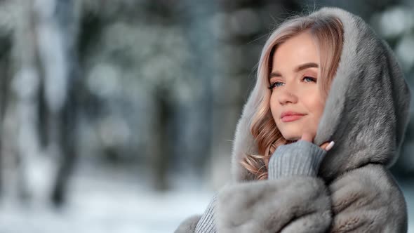 Seductive Happy Woman Posing in Fur Coat at Snowy Winter Forest