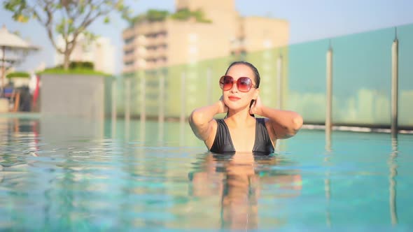 Young asian woman enjoy around outdoor swimming pool for leisure