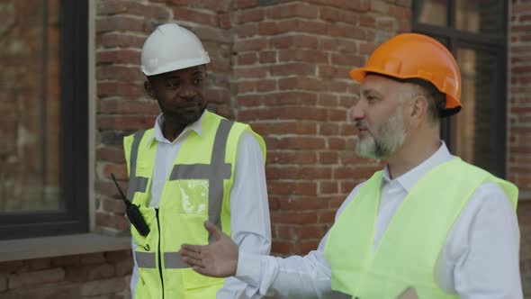 Construction Engineer and Foreman Walking on Building Site