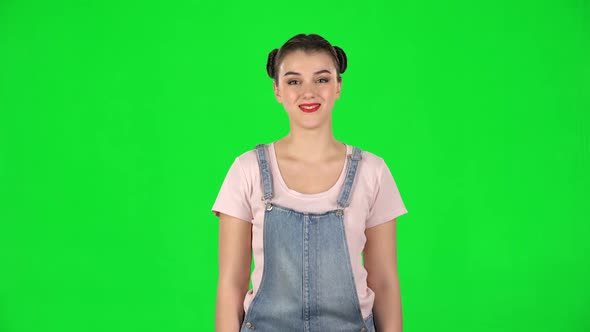Portrait of Smiling Girl with Two Hair-buns on Green Screen