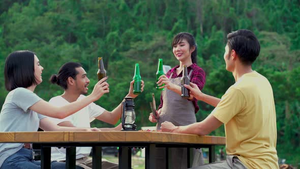 Group of Asian man and woman are having new year party outdoor in the evening together in camping.