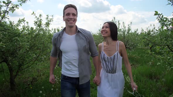 Joyful Couple Running Hand in Hand Among Trees