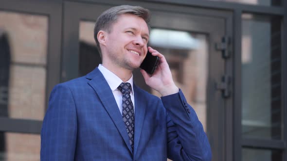 Portrait of Businessman Talking on Phone