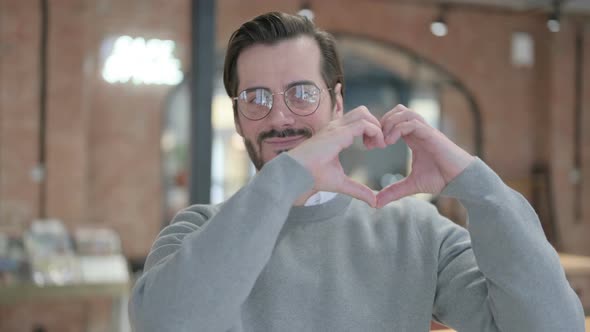 Portrait of Young Man Showing Heart Shape By Hands