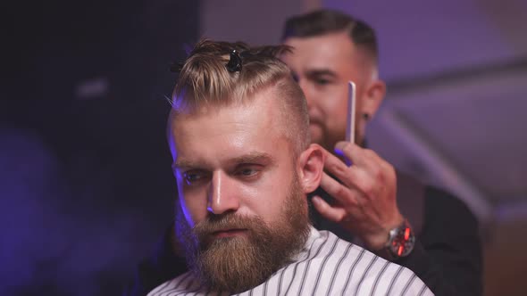 Handsome Caucasian Man in Barber Shop, Barber Trimming Hair To Customer with Electric Razor