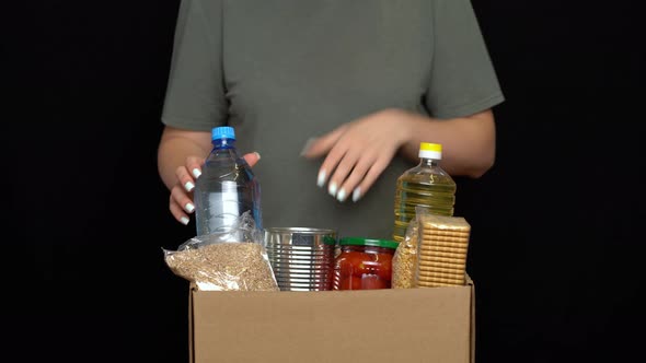 Volunteer Putting Food in a Donation Box. Charity Concept