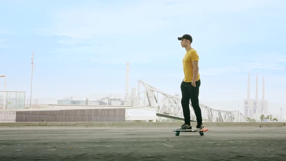 lateral view of a Young Attractive Trendy Man skateboarding fast under a solar panel on a morning su