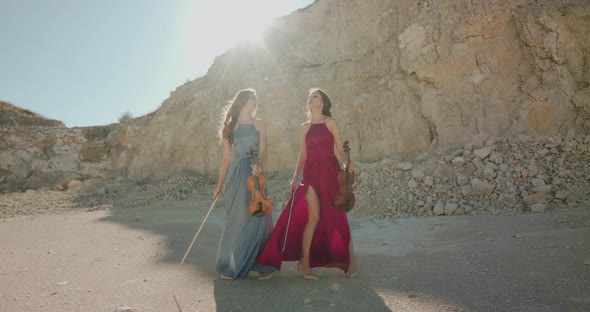 Ladies in Dresses Perform Playing the Violin and Posing on Sunny Nature Under