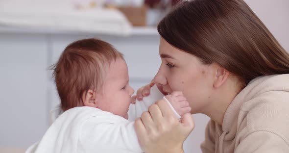 A Caring Mother Plays With Her Newborn Baby