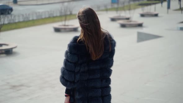 Pensive winter girl in black fur coat outdoors. 