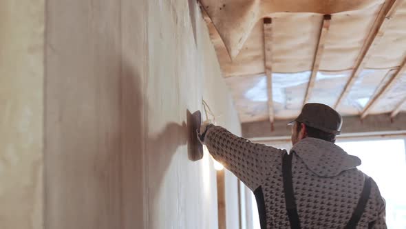 Caucasian Middleaged Male Worker Wearing Peaked Cap Using Palette Knife in Slowmotion