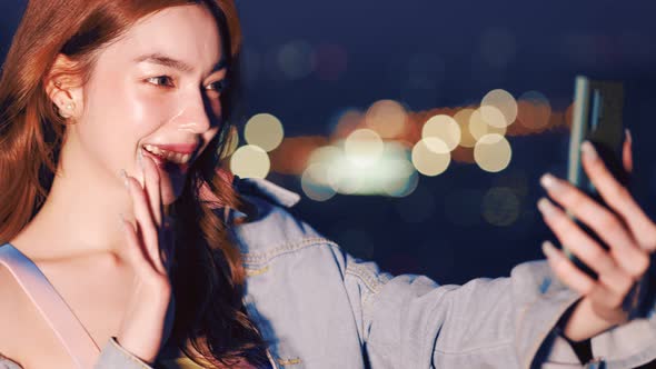 Portrait of smiling pretty young  woman using phone on rooftop