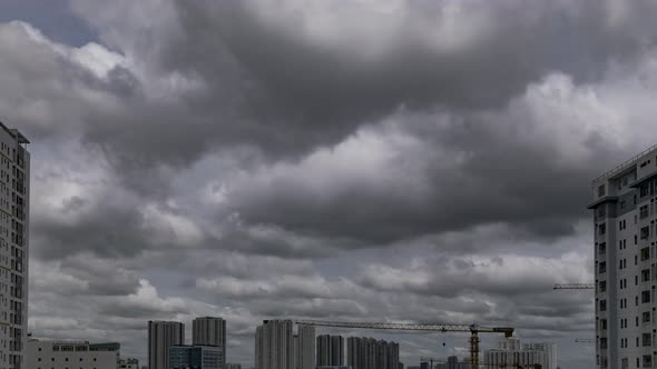 Time lapse of fast moving storm clouds moving from right to left across the sky and high rise buildi alt