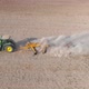 Slowmo - Green tractor plowing an agricultural field leaving big cloud of dust, 4k aerial drone view - VideoHive Item for Sale