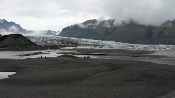 Tourists Hike Near The Skaftafellsjokull Glacier In Southeast Iceland. - aerial forward