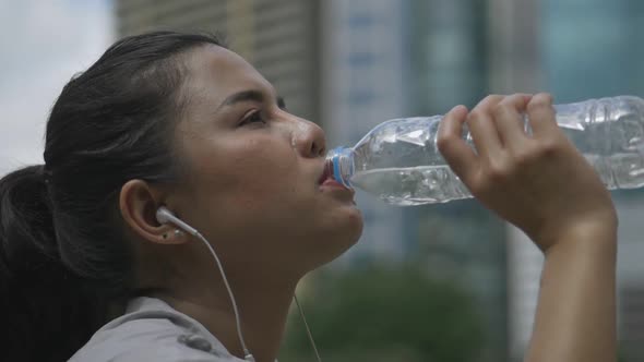 lose-up portrait young Asian woman runner drink water after running.