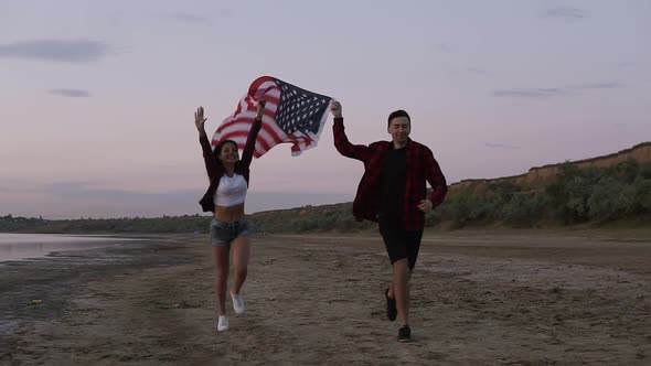 Beautiful Young Two People Running on a Seaside in the Evening