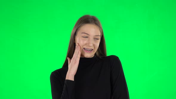 Portrait of Awkward Teenage Girl Is Thinking About Something on a Green Screen