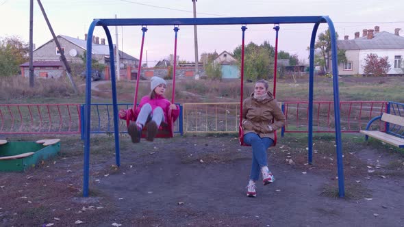 Girl And Woman On A Swing