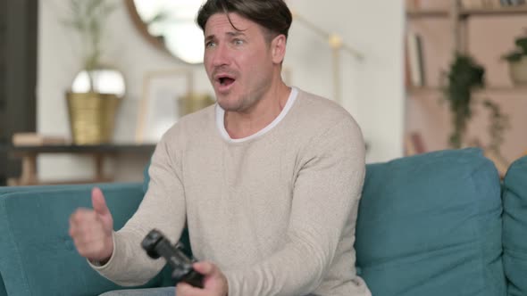 Middle Aged Man Reacting To Loss in Video Game at Home 