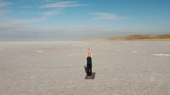 Young woman praticing yoga in a wild place. Sun salutation (surya namaskar) vinyasa flow - Lake Tuz,