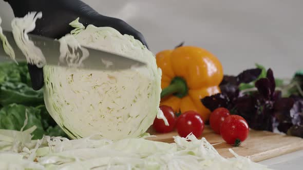 Chef Cuts the Cabbage with a Knife in Slow Motion Making a Salad Fresh Vegetables on a Cutting Board