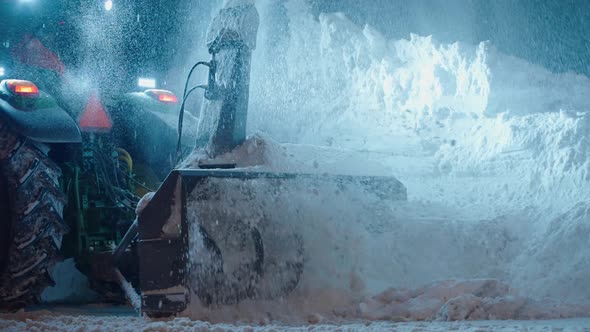 Snow plow blower truck cleaning thick snow after blizzard storm from road at night