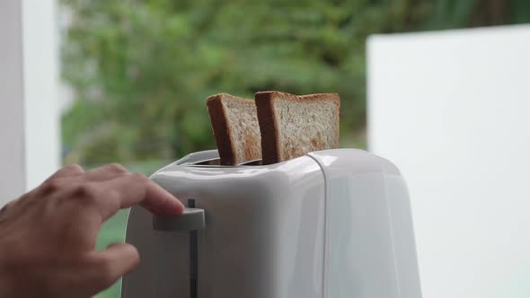 Putting Bread Into Toaster