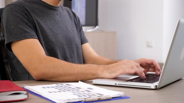 Man in Casual Clothes Typing Fast on Laptop Keybord