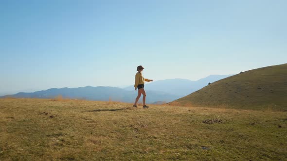 Hipster Woman Walk on Mountain Peak in Sunshine