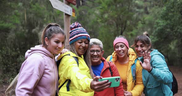 Multi generational women having fun during trekking day taking using mobile phone for video call