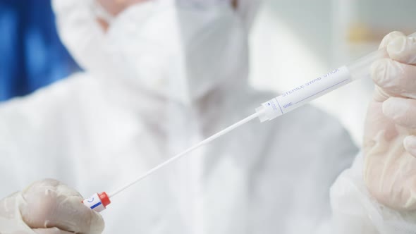 Opening PCR Test in Laboratory Doctor Looking at COVID19 Swab Collection Kit Lab Worker Wearing PPE