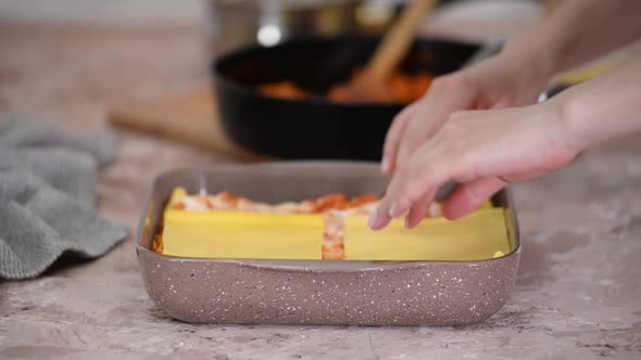 Woman Making Layer Lasagna on the Kitchen