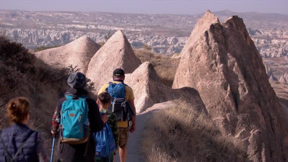 Tourists Walking in Rock Formation in the Valley at Cappadocia.