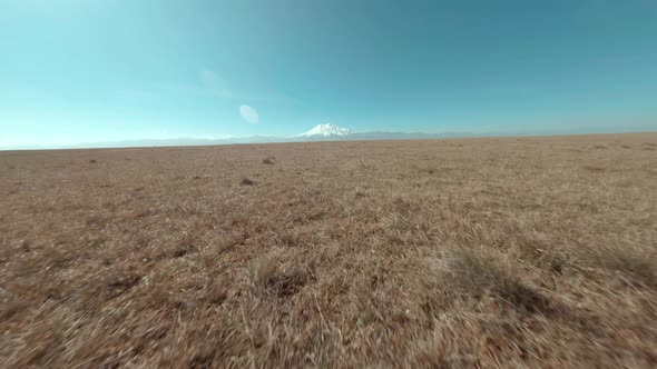 Fpv Sport Drone Fast Flying Over Mountain Plain on Snowy Elbrus Background. Amazing Aerial View