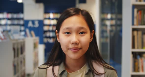 Asian Girl Student Looking at Camera Walking in Bookstore