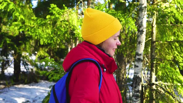 Girl is Walking Through the Winter Forest