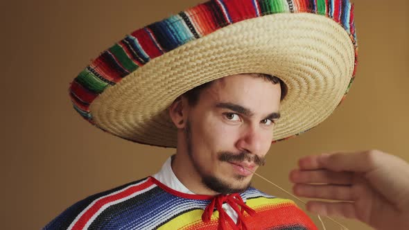 Young Mexican In Multicolored Poncho And Hat