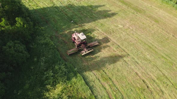 Mower Rides Through the Meadow Accompanied By a Stork