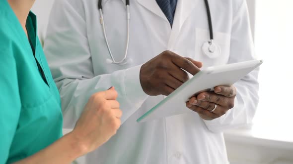 Closeup View of Man and Woman Doctors Using Tablet During Working Day at Clinic Spbas