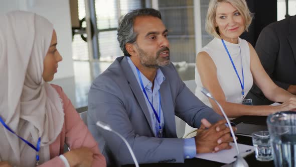 A panel of business delegates talking at a conference