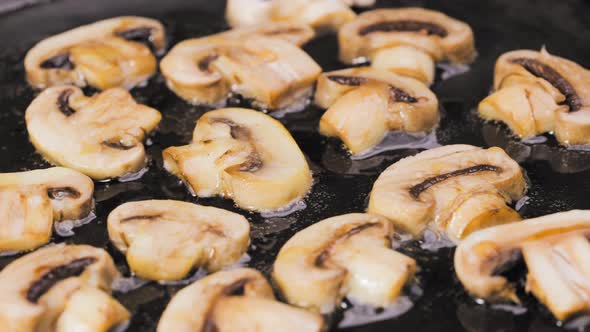 Sliced Champignon Mushrooms are Fried in a Hot Pan in Close Up