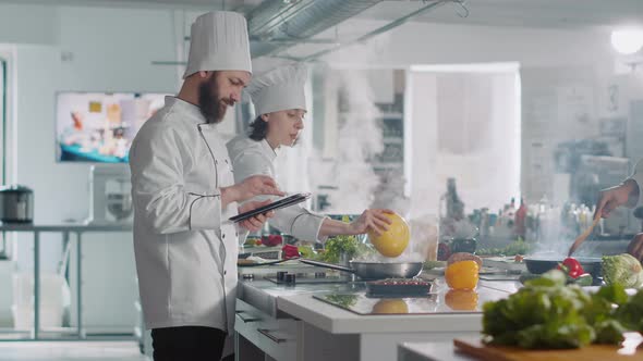 Male Cook Analyzing Culinary Recipe on Digital Tablet in Kitchen