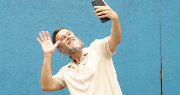 Caucasian Middleaged Man Makes a Video Call with a Mobile Phone