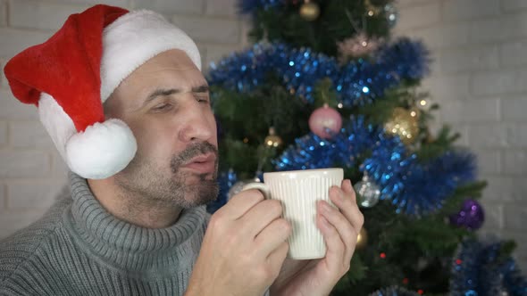 Male Hold Hot Christmas Tea in Room