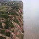 Quadcopter Flies Over Hills and a Wide River Approaching a Village - VideoHive Item for Sale