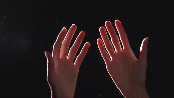 Silhouette Portrait of Two Caucasian Female Arms Closeup Raised Upward and Turning Against Shining