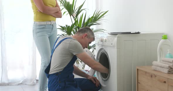 Technician checking a broken washing machine